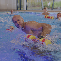 Teilnehmer eines Aqua Fitnesskurses im Schwimmbecken