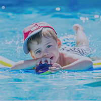 Kleinkind spielt im Wasser auf Wasserspielplatz